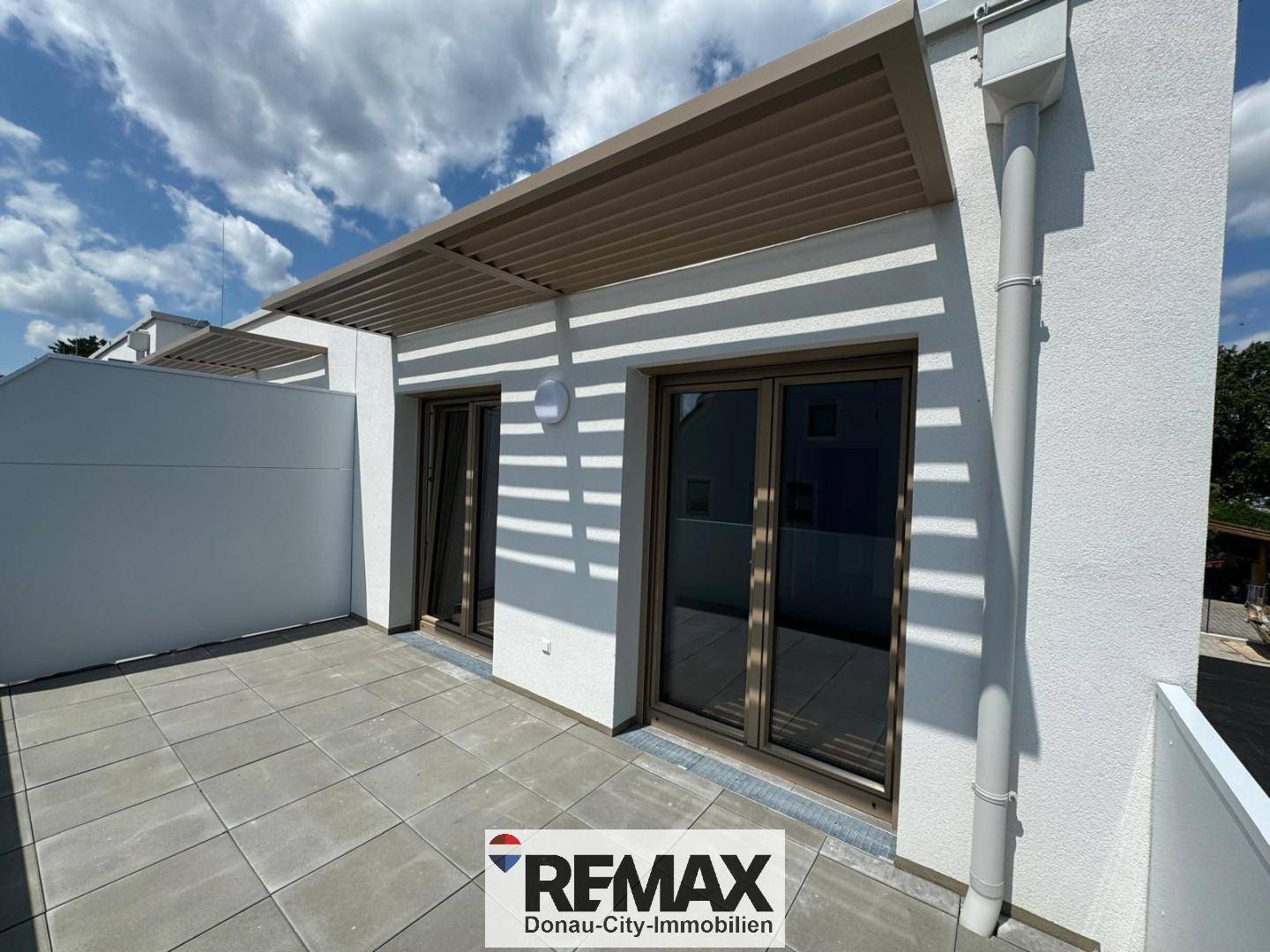 Geräumige Dachterrasse mit Fliesenboden und moderner Pergola, bietet Platz für Outdoor-Möbel.