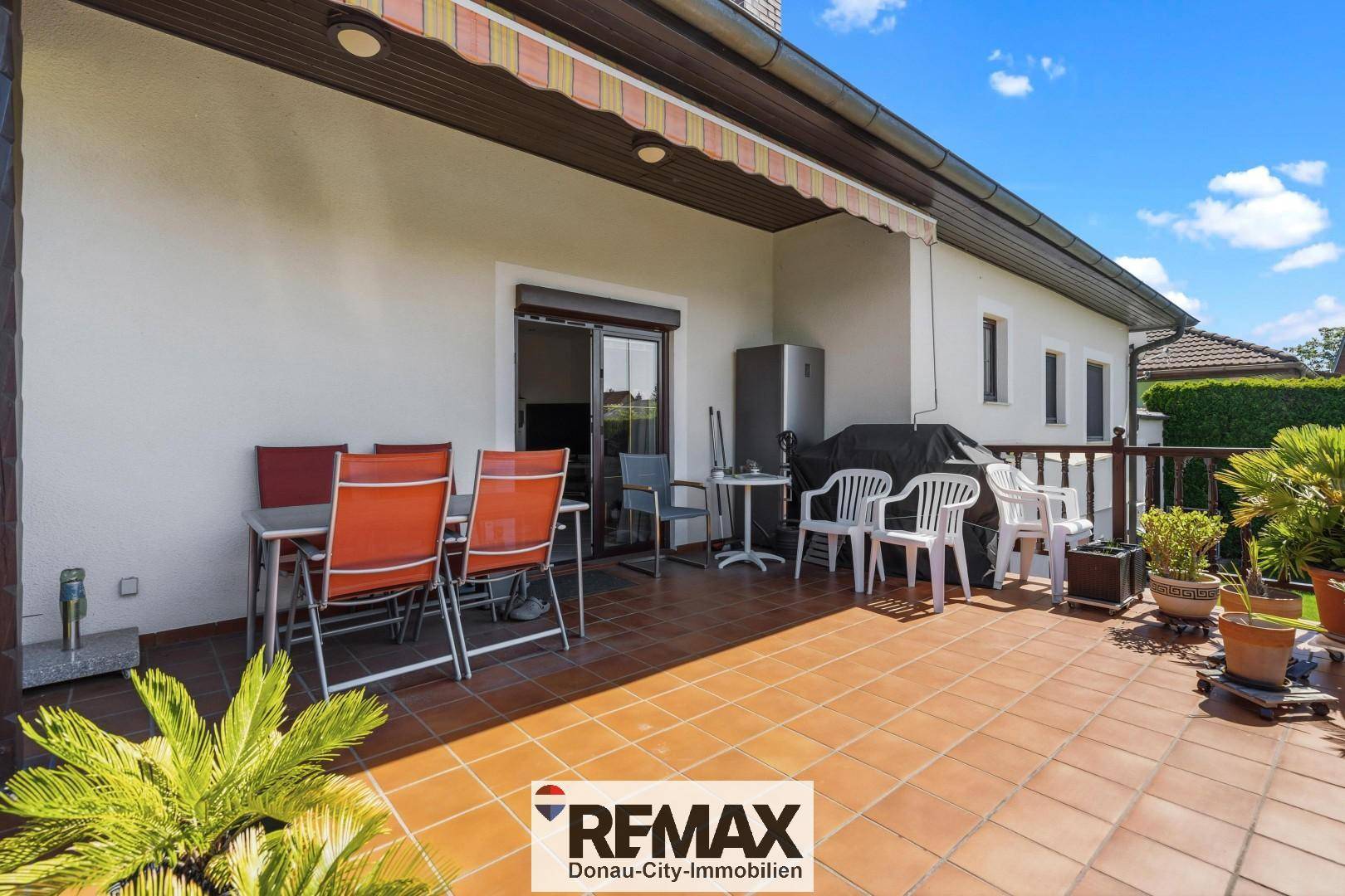 Geräumige Terrasse mit Markise, Gartenmöbeln und Grillbereich für entspannte Stunden im Freien.