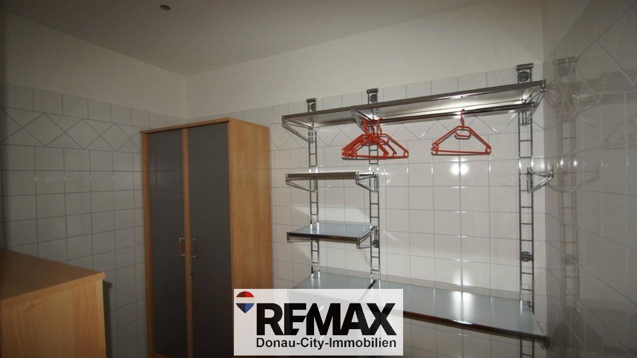 Praktischer Abstellraum mit Regalsystemen und einem kleinen Schrank, ideal für Lagerung.