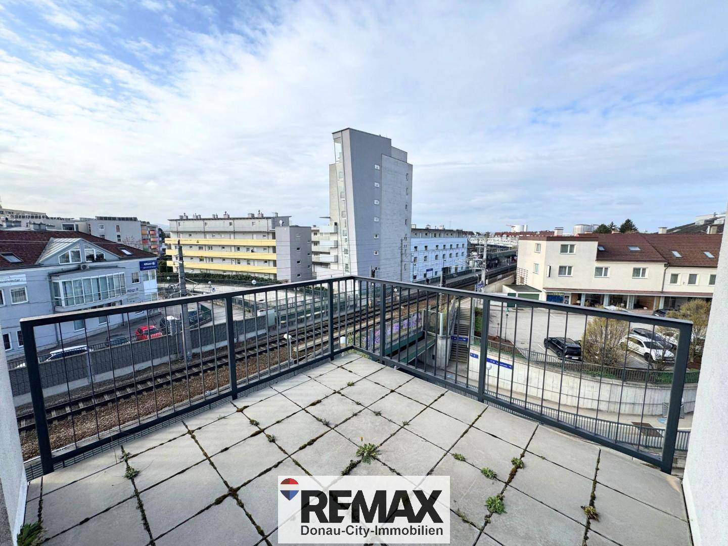 Balkon mit Blick auf die Bahngleise und die umliegende städtische Bebauung.