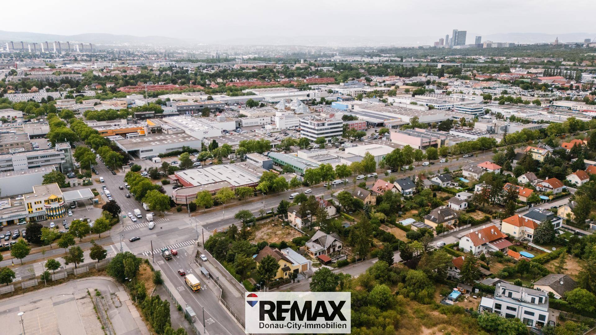 Panoramablick aus der Luft auf eine Stadtlandschaft mit Wohn- und Gewerbegebäuden.