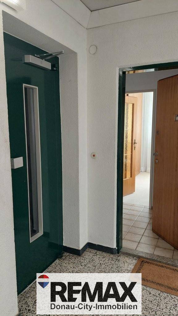 Eingangsbereich mit Terrazzoboden und zwei Türen, die zu verschiedenen Räumen führen.