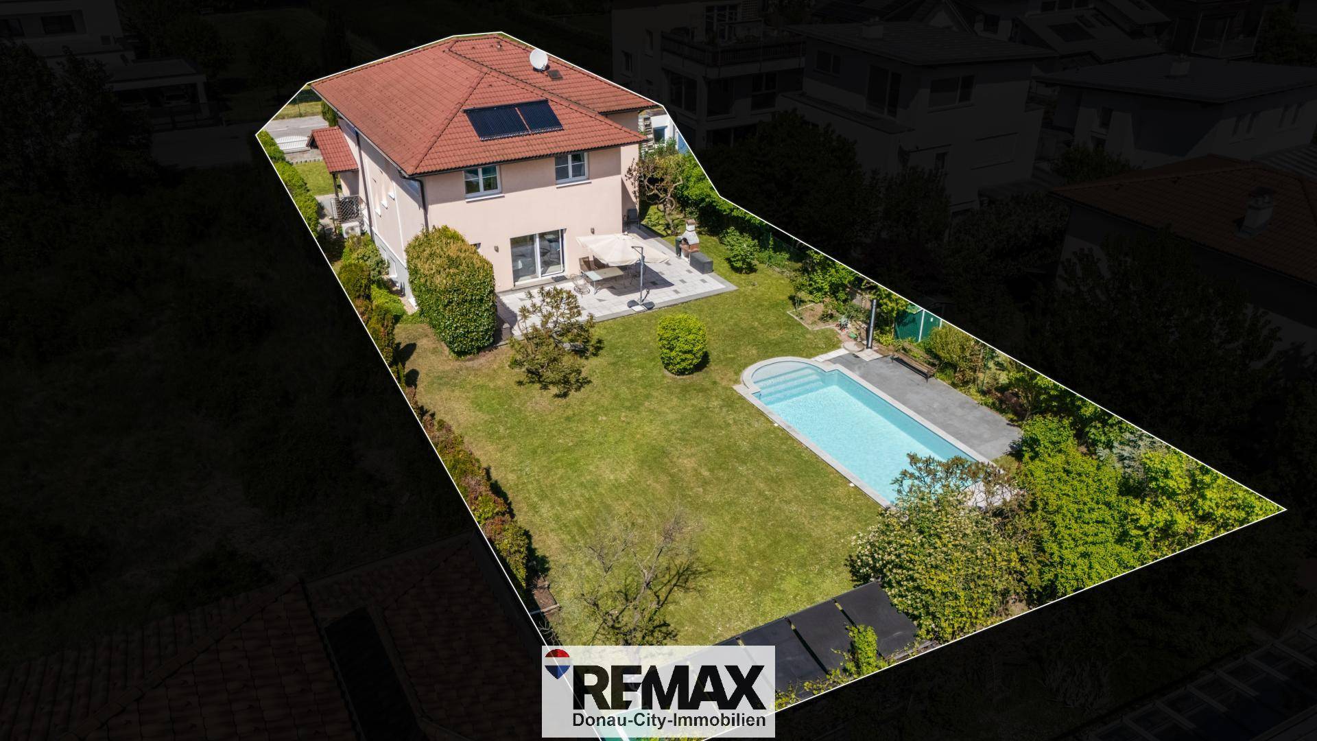 Übersichtliche Luftaufnahme des Anwesens mit Haus, Garten und Swimmingpool.