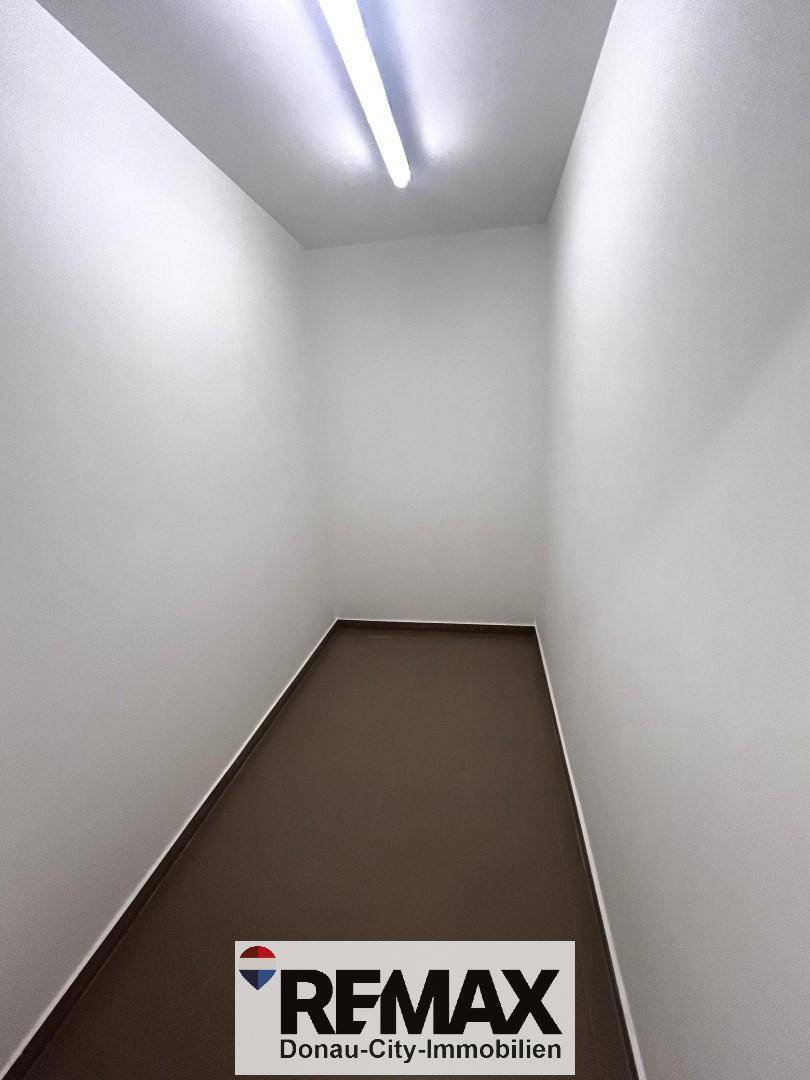 Kleiner, leerer Abstellraum mit weißen Wänden und dunklem Boden für zusätzlichen Stauraum.