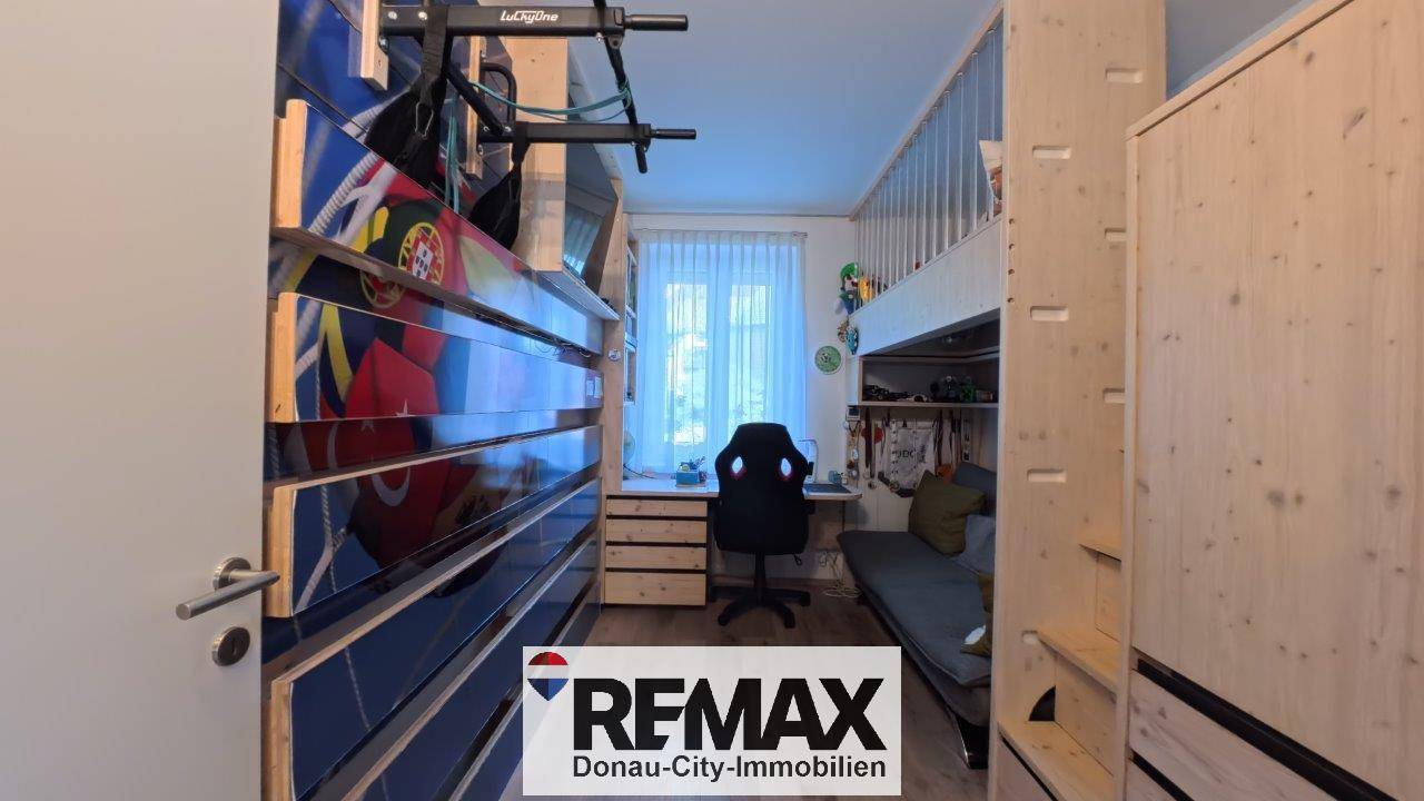 Kinderzimmer mit Hochbett, Schreibtisch und Kletterwand.