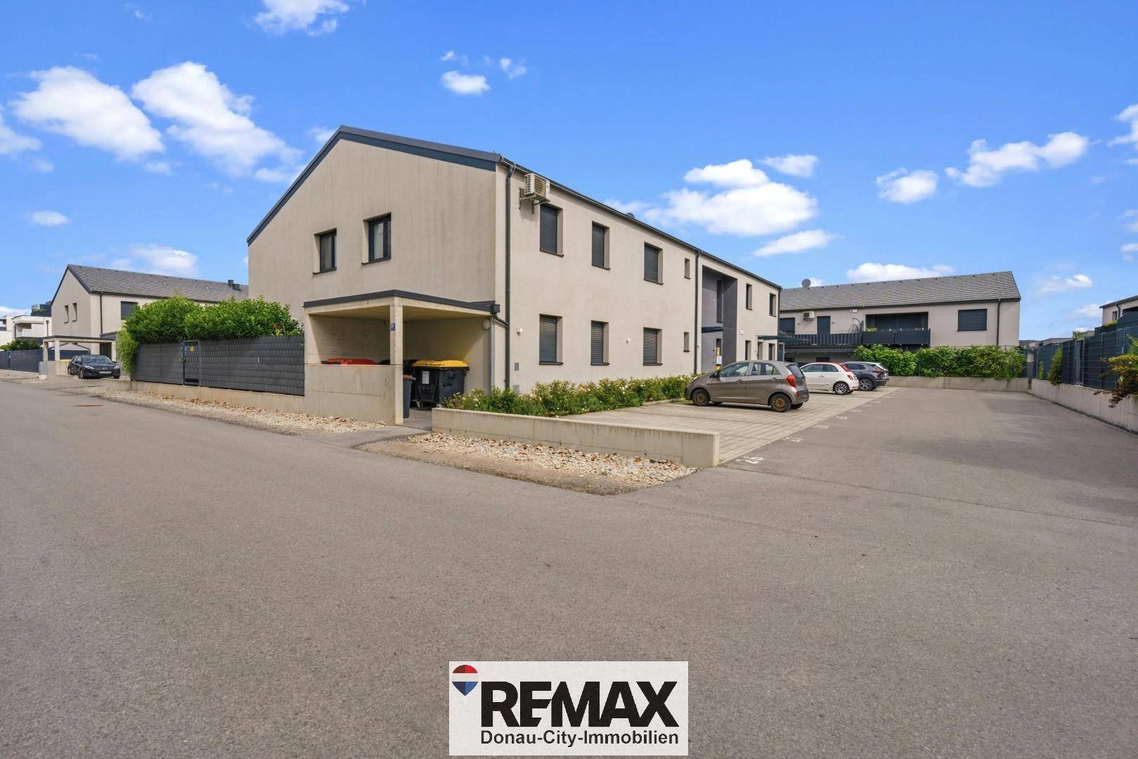 Modernes Mehrfamilienhaus mit Parkplätzen und gepflegter Außenanlage in ruhiger Lage.