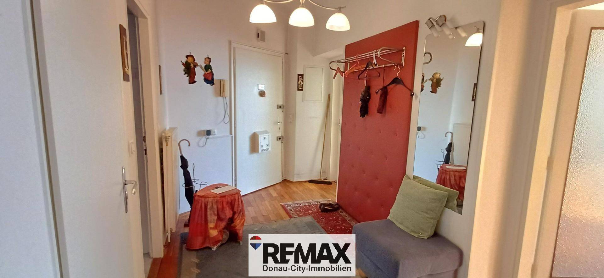 Heller Eingangsbereich mit Spiegel, Garderobe und einem kleinen Tisch, der zum Verweilen einlädt.