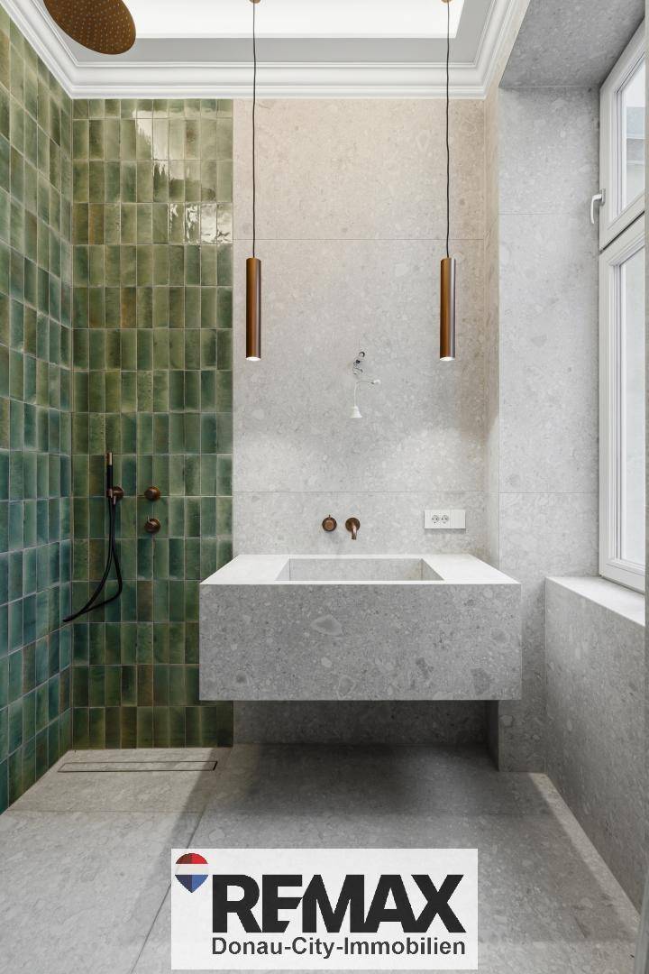 Modernes Badezimmer mit grünen Fliesen in der Dusche, großem Waschbecken und grauen Steinfliesen.