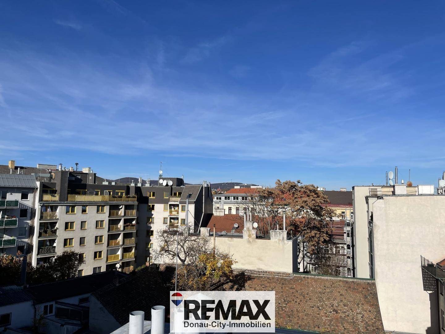 Weitblick über die Dächer der Stadt unter blauem Himmel.