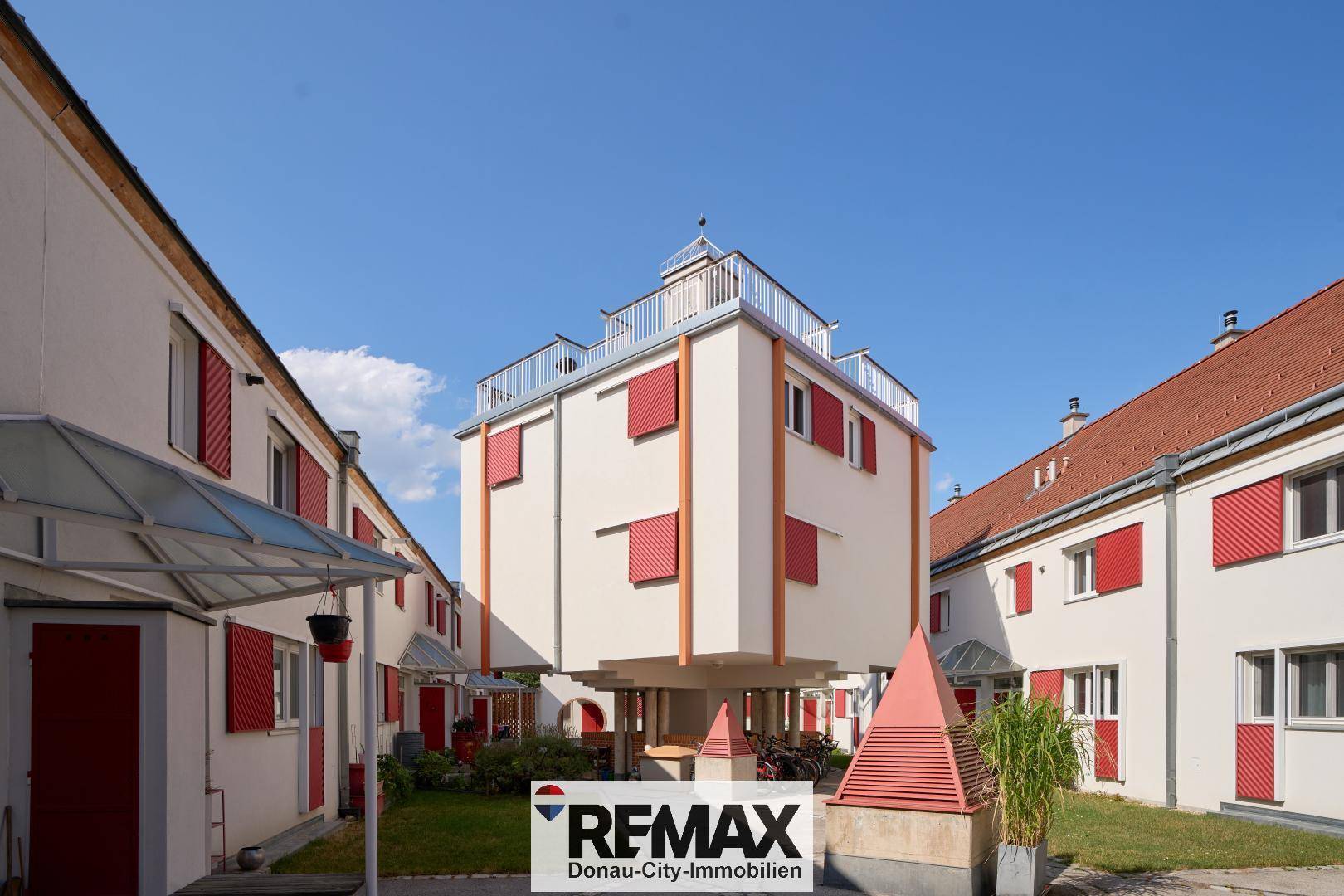 Innenhofansicht von Wohngebäuden mit markanter Architektur und roten Akzenten.