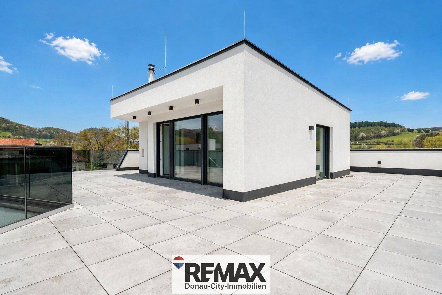 Moderne Architektur auf einer weitläufigen Dachterrasse mit Panoramablick auf die Umgebung.