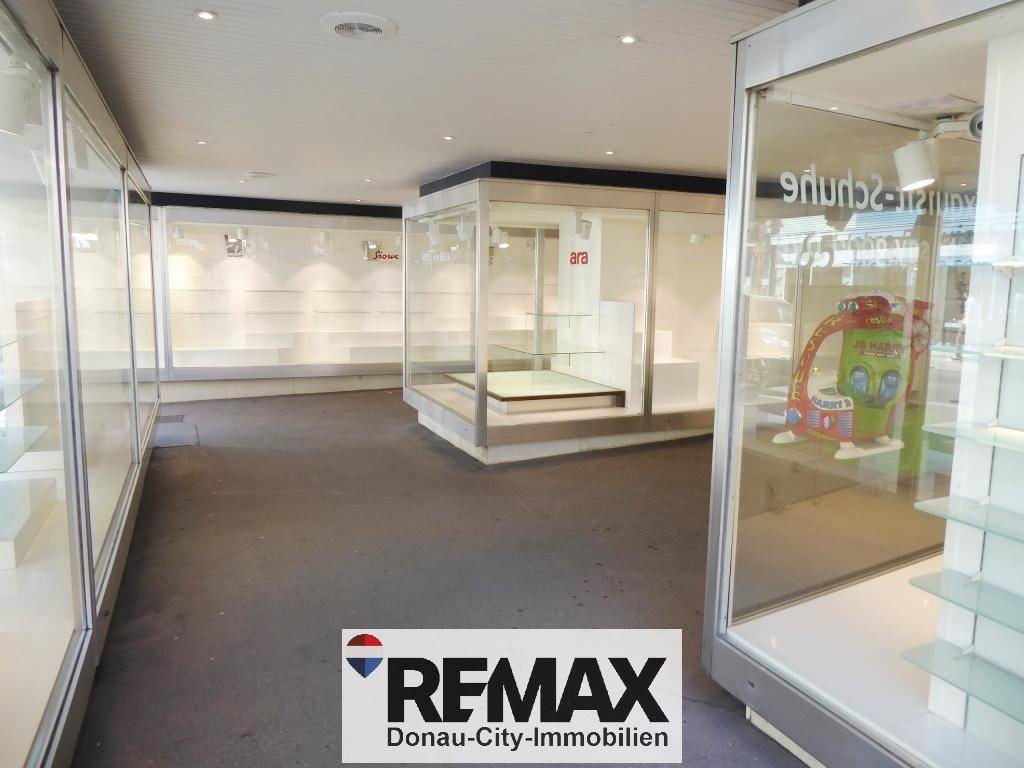 Leerer Ladenbereich mit großen Schaufenstern und Ausstellungsflächen, bereit für neue Mieter.