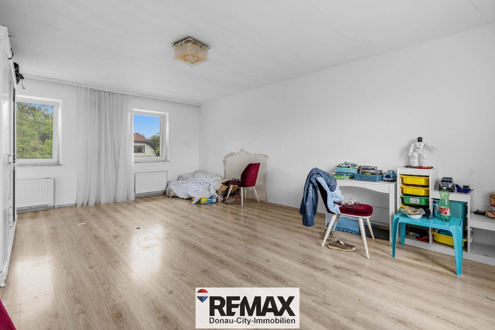Kinderzimmer oder Gästezimmer mit Laminatboden, Fenster und viel Platz.