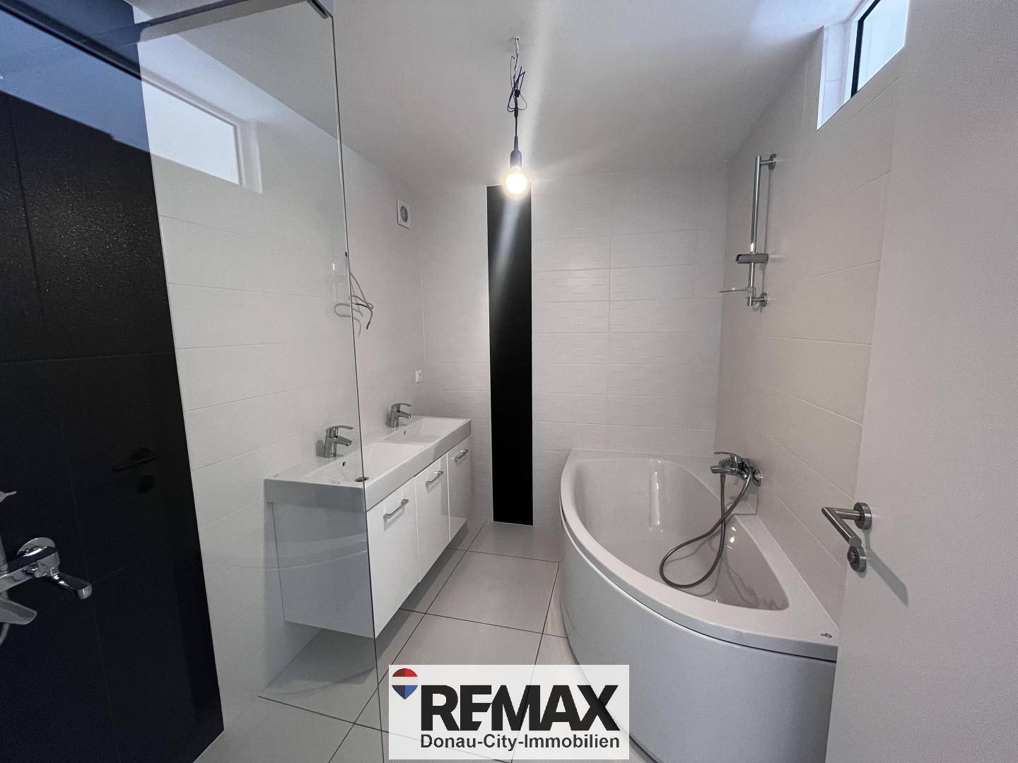 Modernes Badezimmer mit Eckbadewanne, Doppelwaschbecken und einer begehbaren Dusche.