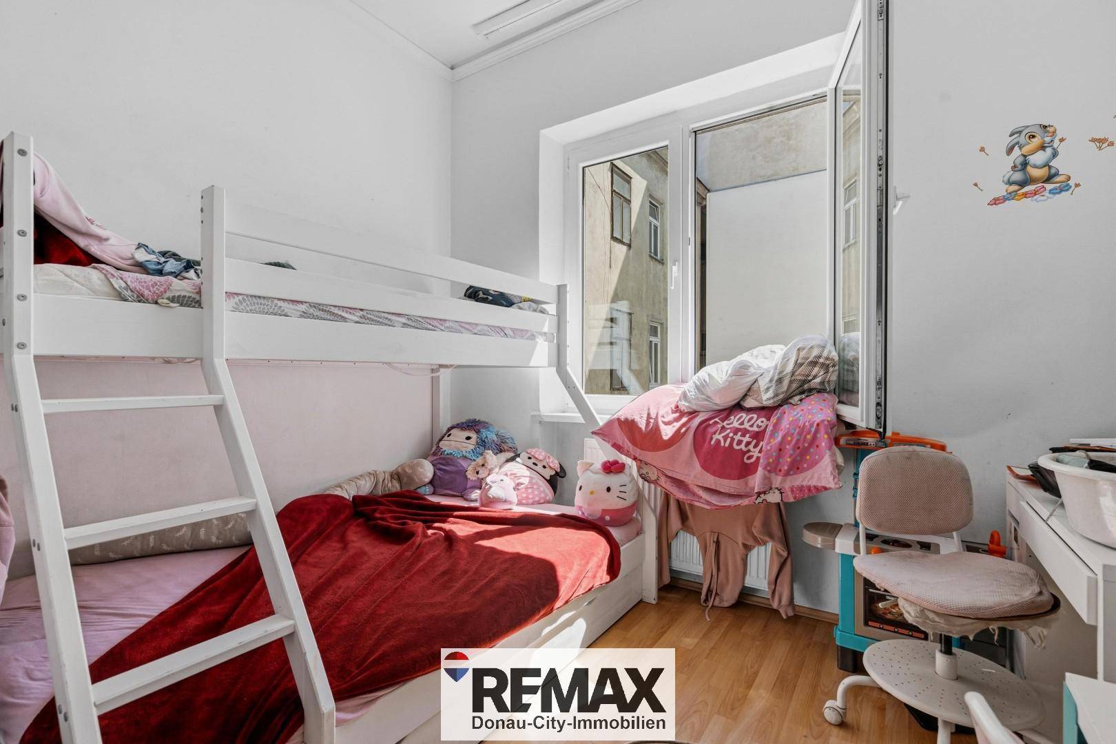 Kinderzimmer mit Etagenbett, Schreibtisch und hellem Fenster, ideal für Geschwister.