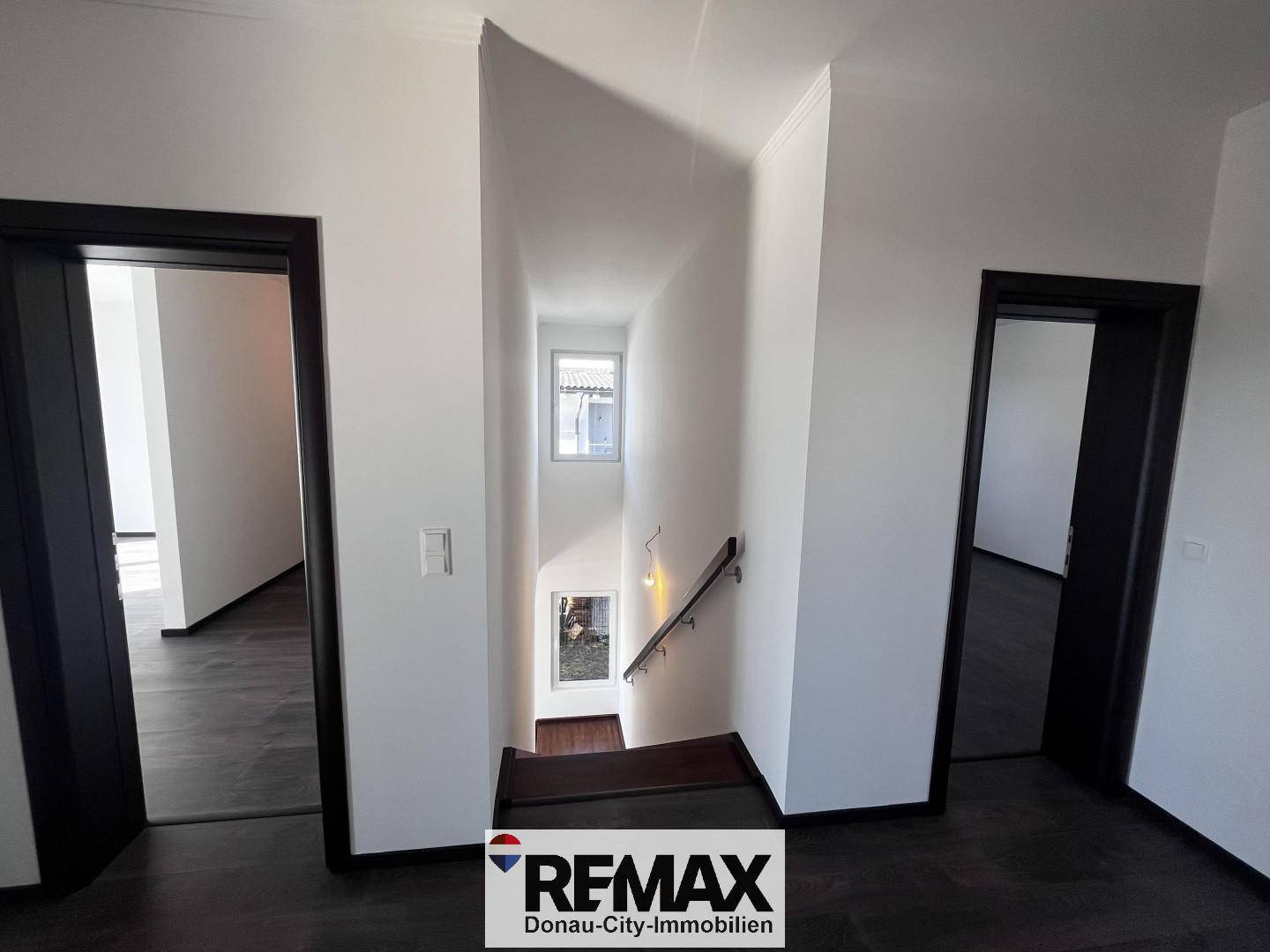 Heller Treppenabsatz mit Blick auf die untere Etage und Zugang zu weiteren Räumen.