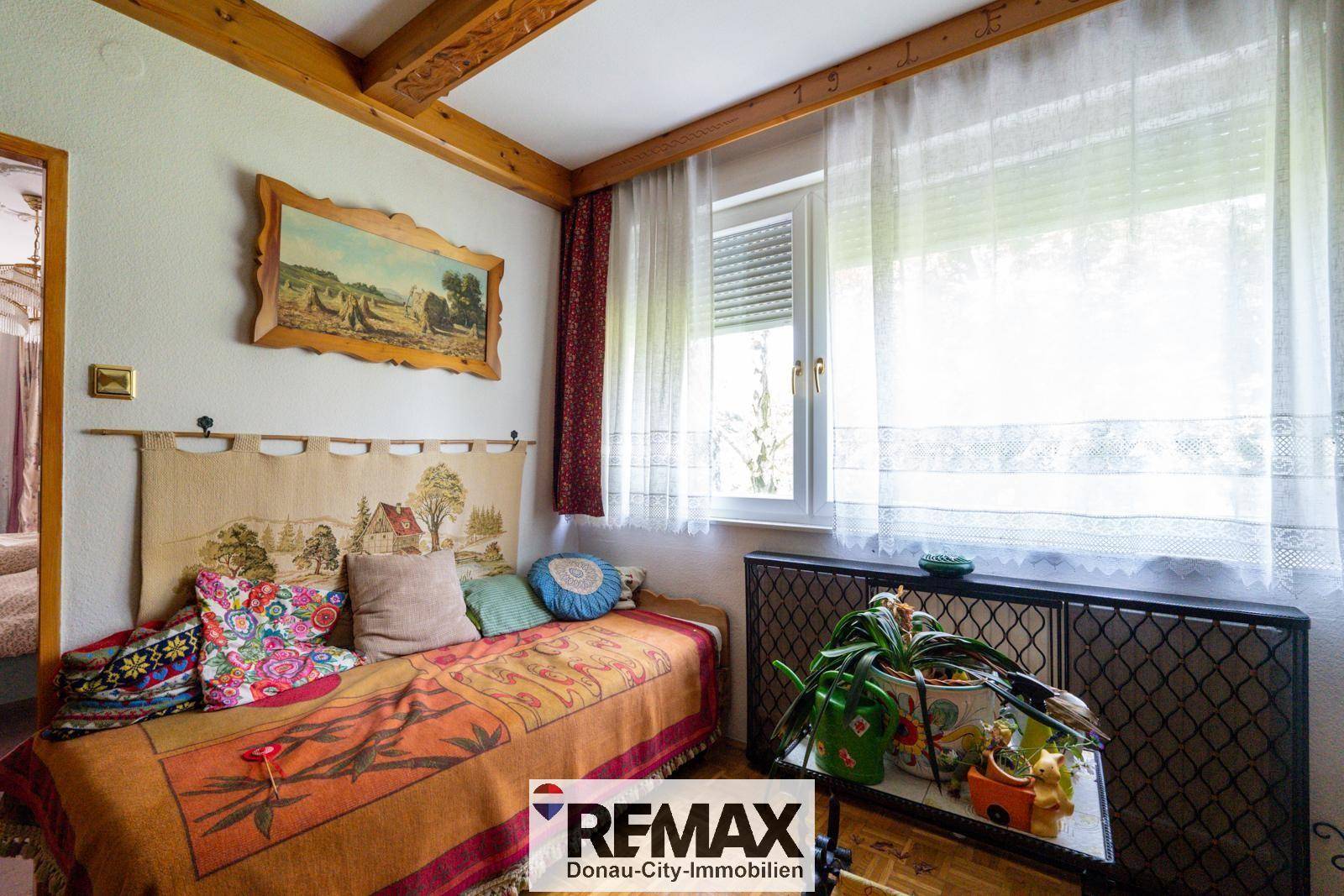 Helles Zimmer mit Tagesbett, Fenster und traditioneller Dekoration.