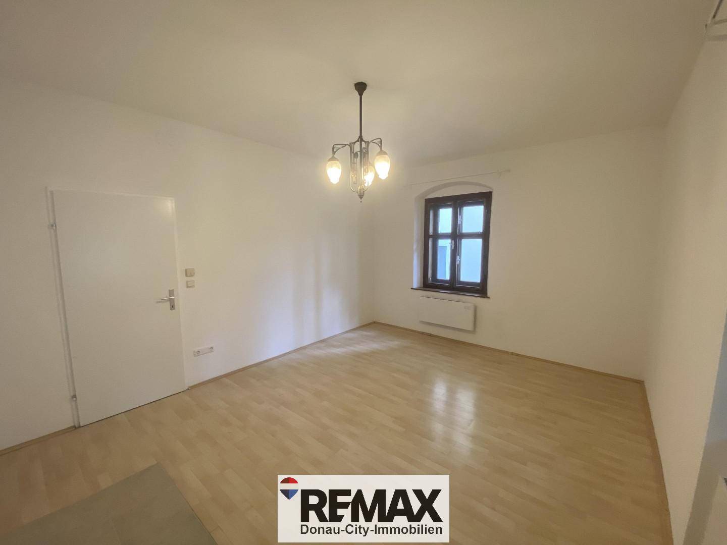 Geräumiges Zimmer mit hellem Parkettboden und einem Fenster, bereit zur individuellen Gestaltung.