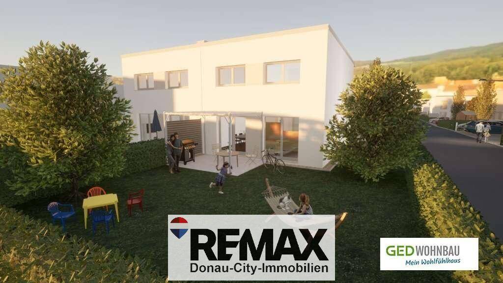 Moderne Hausfassade mit Terrasse und Garten, ideal für Familienaktivitäten im Freien.