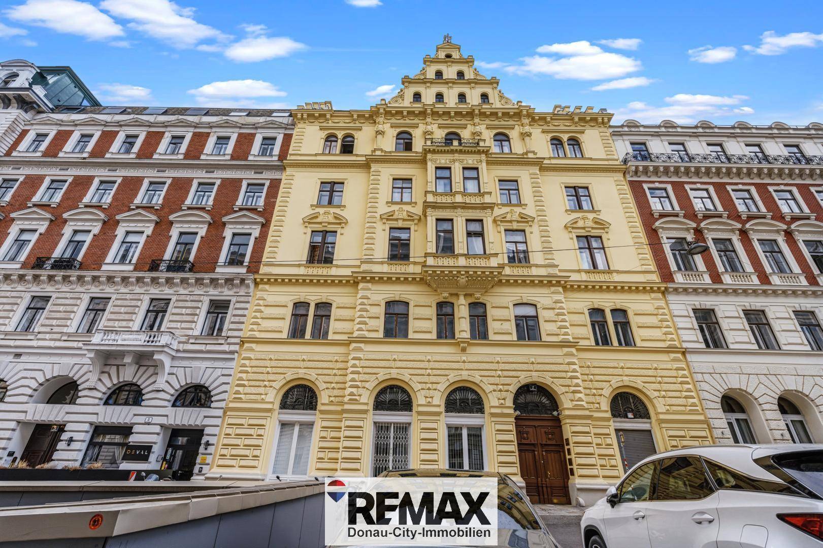 Prächtige historische Fassade eines Altbaus mit reicher Ornamentik und vielen Fenstern in der Stadt.