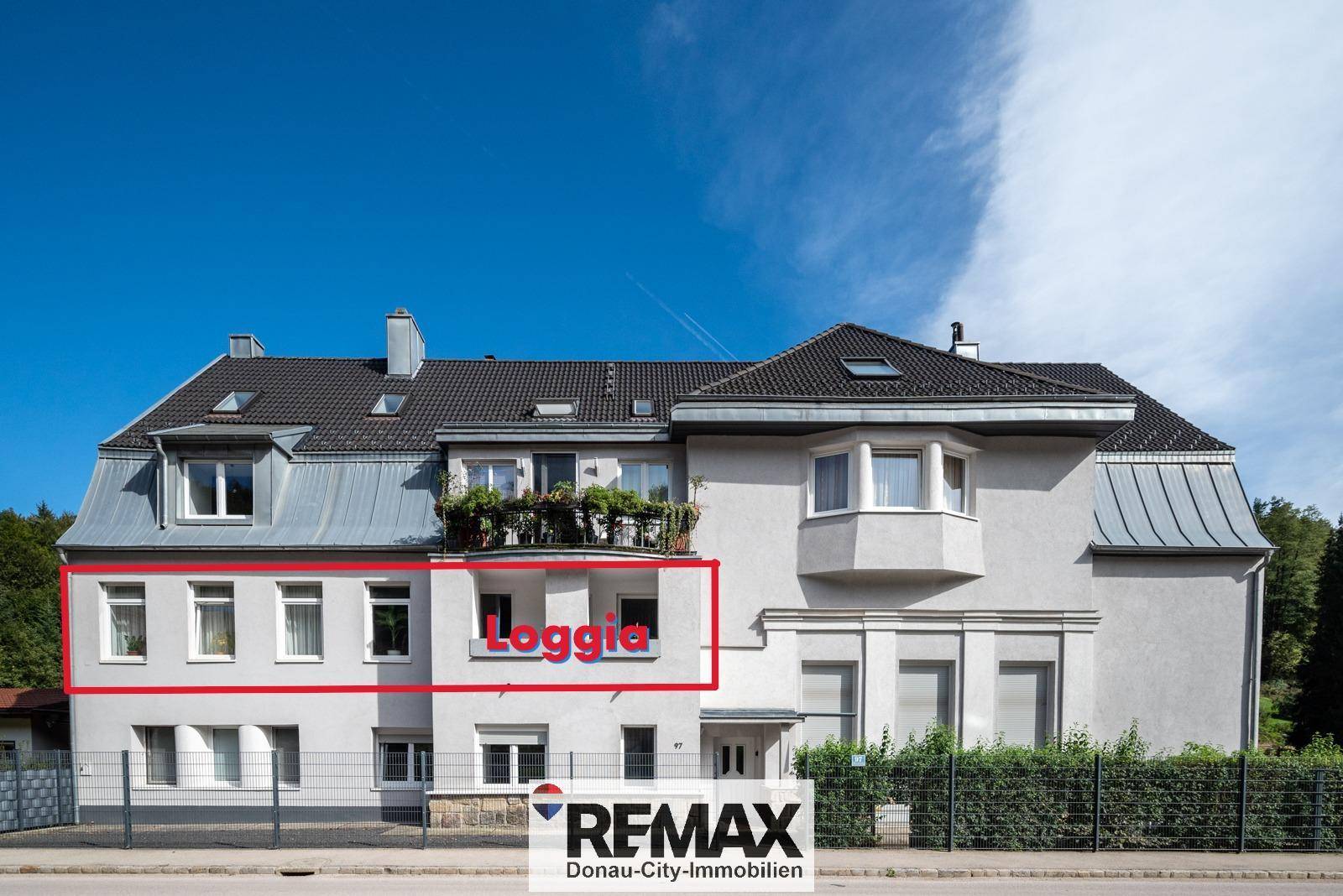 Außenansicht eines Gebäudes mit einer hervorgehobenen Loggia und traditioneller Architektur.