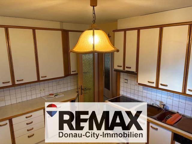 Traditionelle Küche mit weißen Schränken, Holzdetails und gefliestem Spritzschutz.