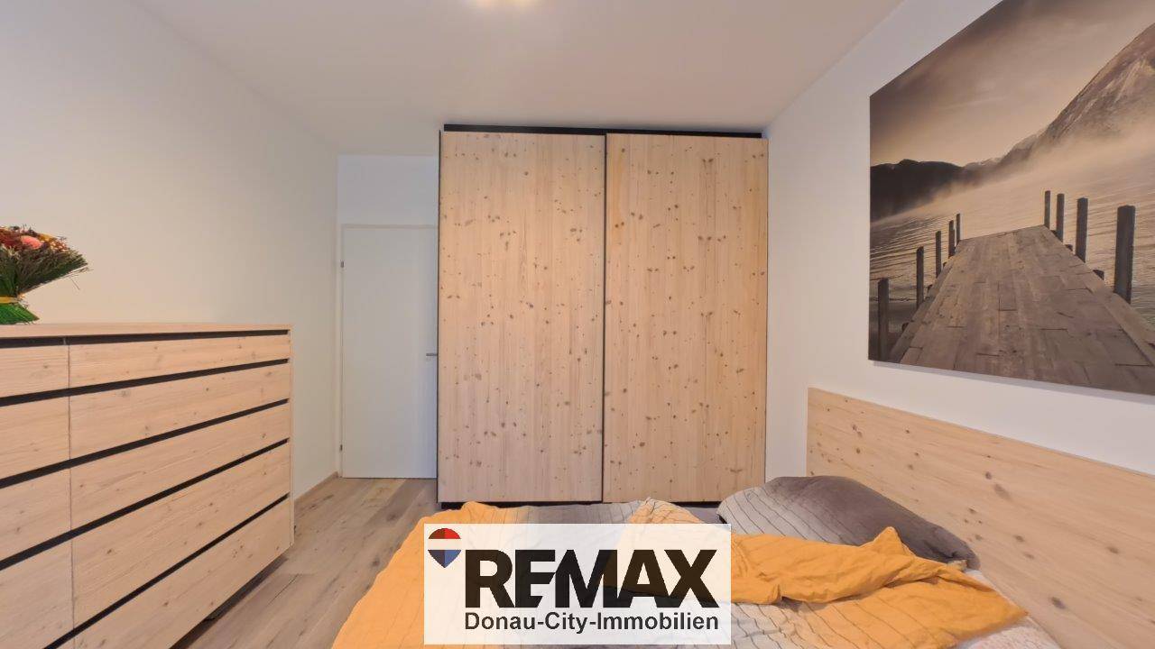 Schlafzimmer mit großem Holzschrank und passendem Bettrahmen.