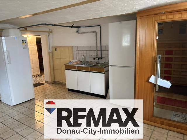 Kellerbereich mit kleiner Küchenzeile, Kühlschränken und integrierter Sauna.