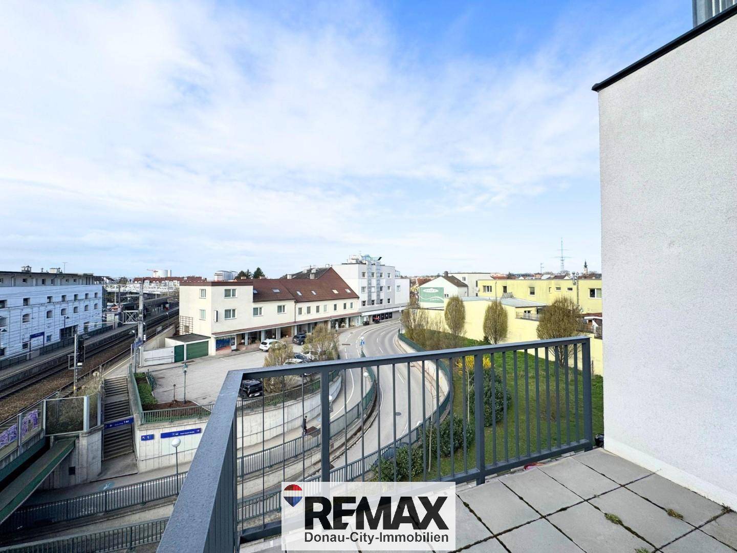 Balkon mit weitem Blick über die Stadt, die Straße und die Bahnanlagen.