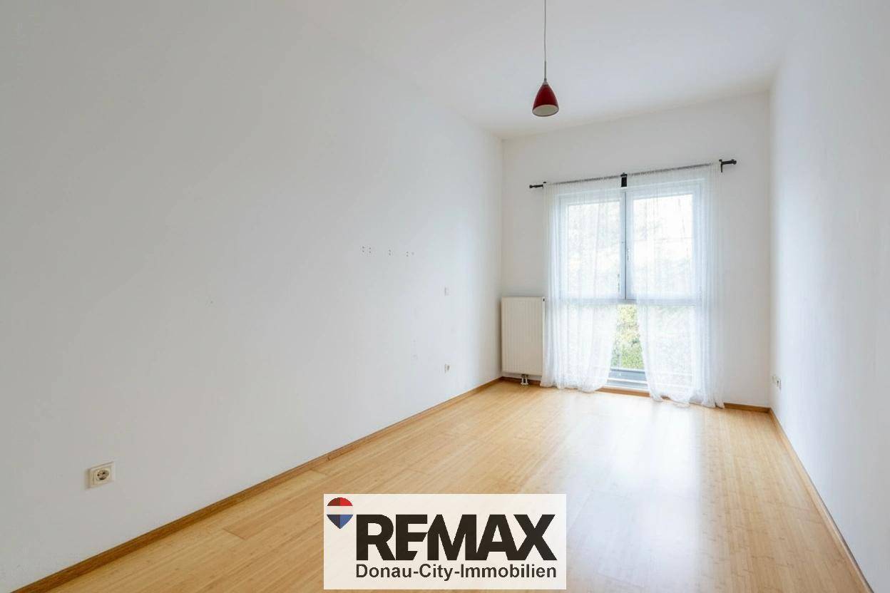 Leeres Zimmer mit hellem Holzfußboden und Fenster, ideal als Schlaf- oder Arbeitszimmer.