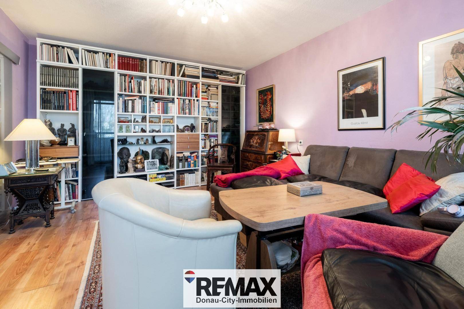 Wohnzimmer mit großer Bücherwand, Sofa und orientalischem Teppich.
