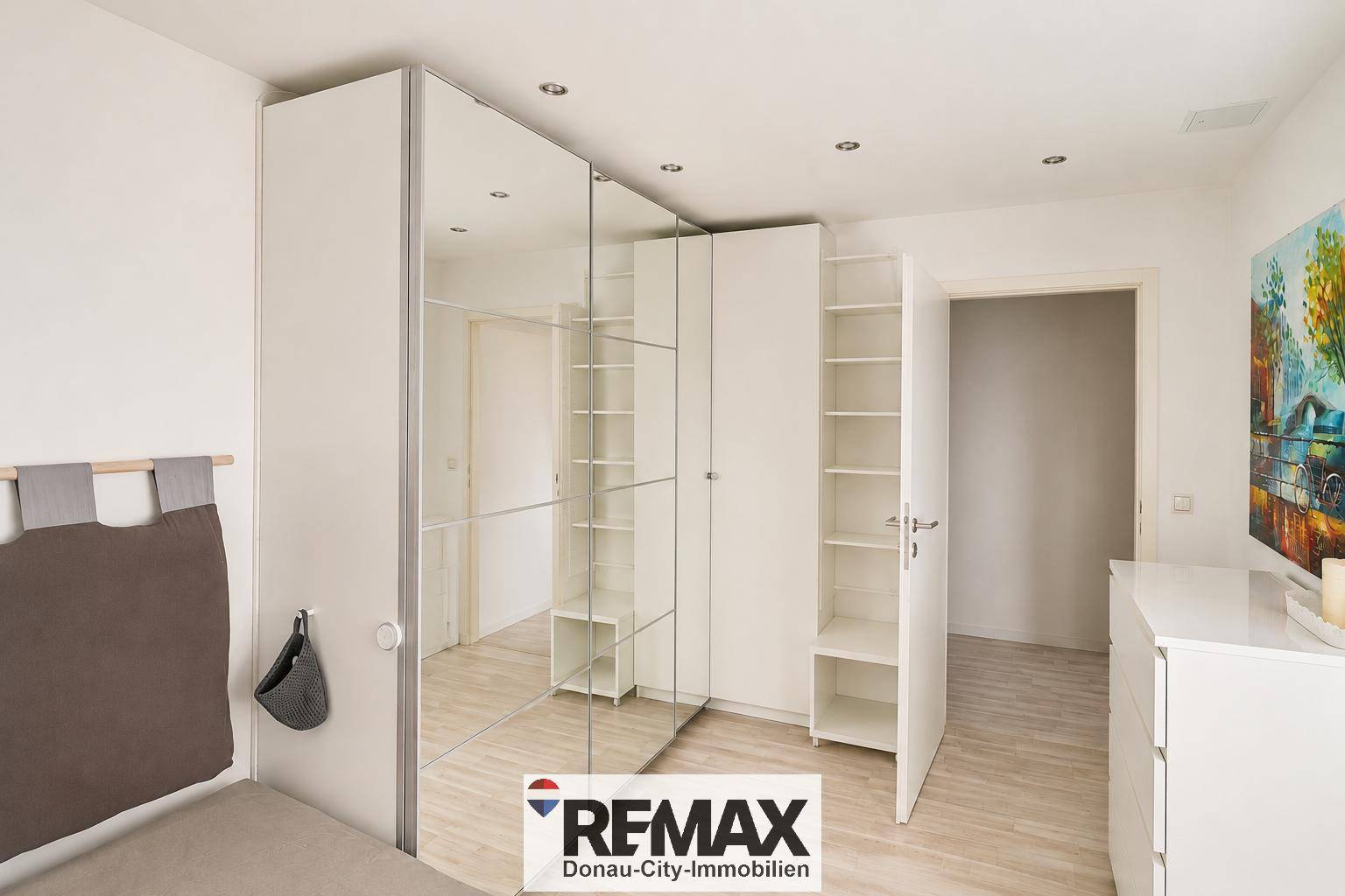 Schlafzimmer mit großem Spiegelschrank, der viel Stauraum bietet.