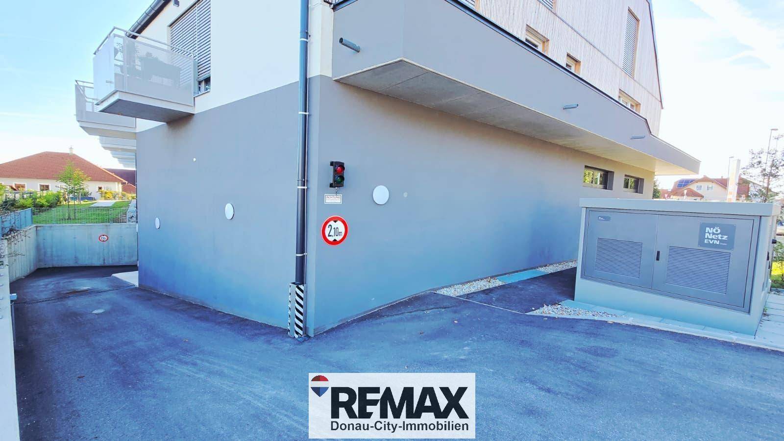 Eingang zur Tiefgarage mit Rampe und moderner Gebäudearchitektur.