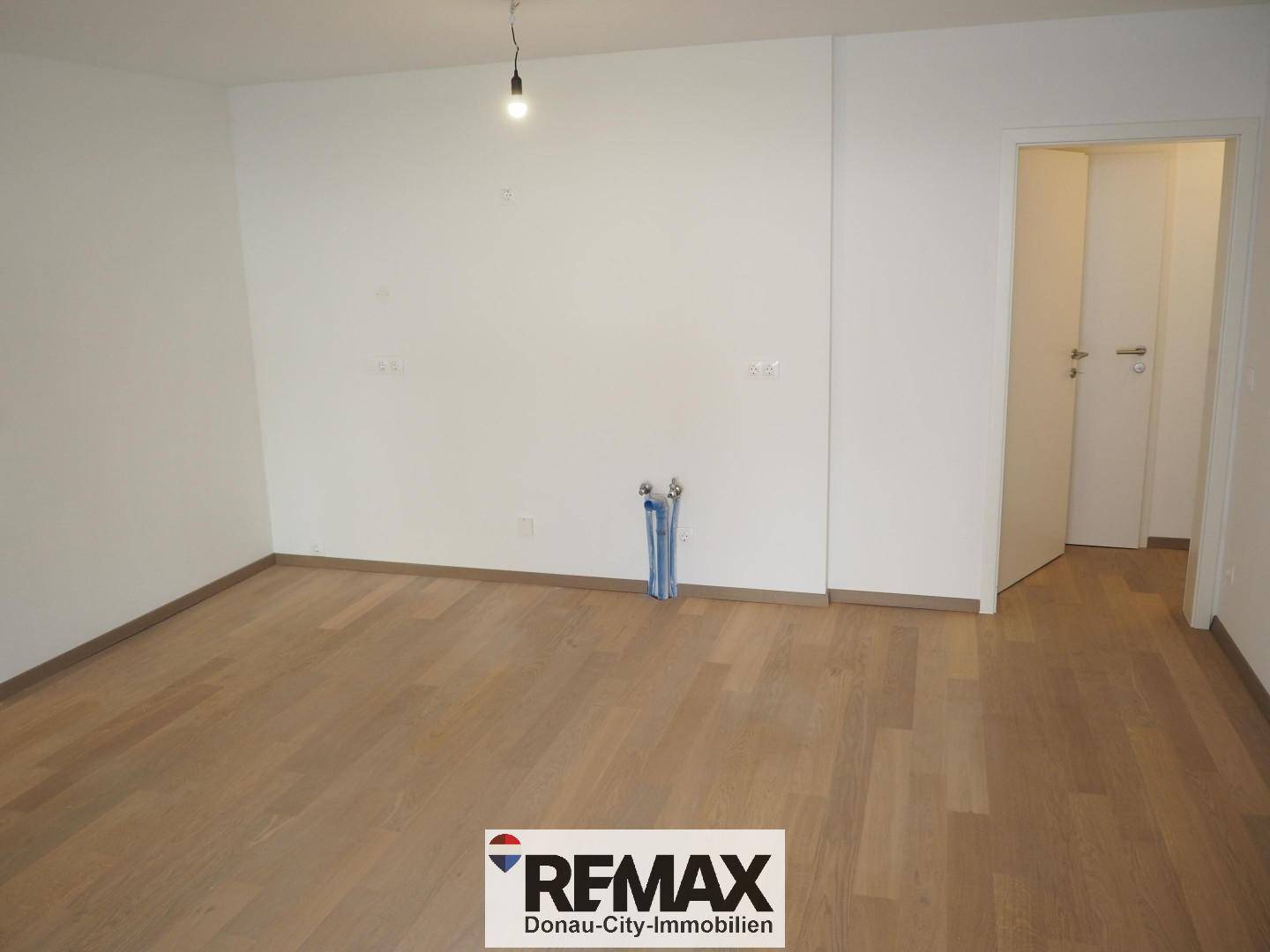 Leerer Raum mit Holzboden und vorbereiteten Anschlüssen, vielseitig nutzbar.