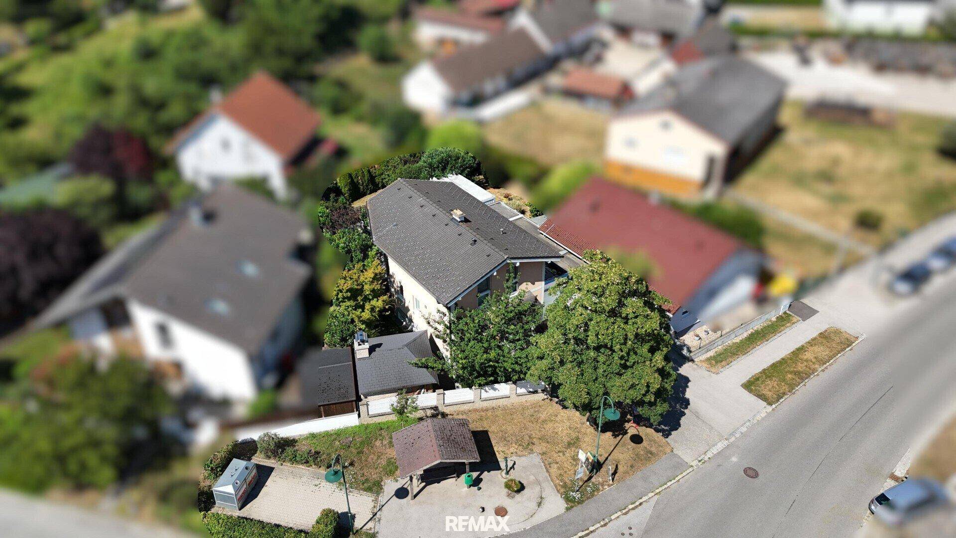 Weitläufige Luftaufnahme des Hauses in einer grünen Wohngegend.