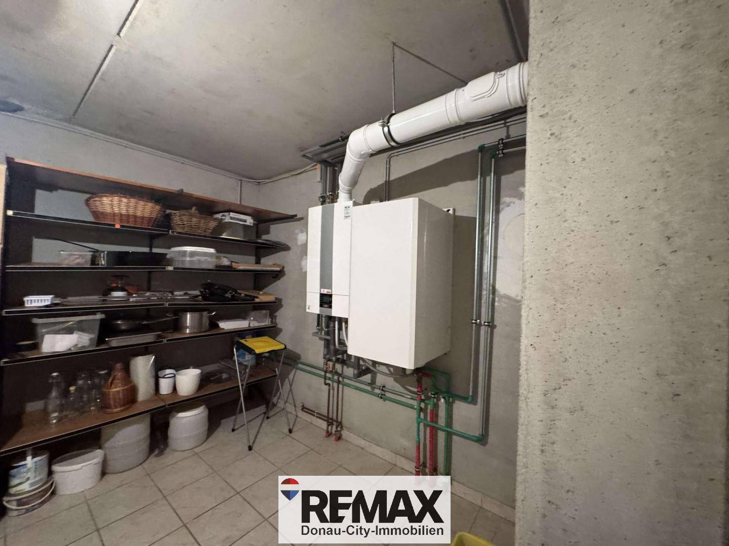 Hauswirtschaftsraum im Keller mit Heizungsanlage, Regalen und Fliesenboden.
