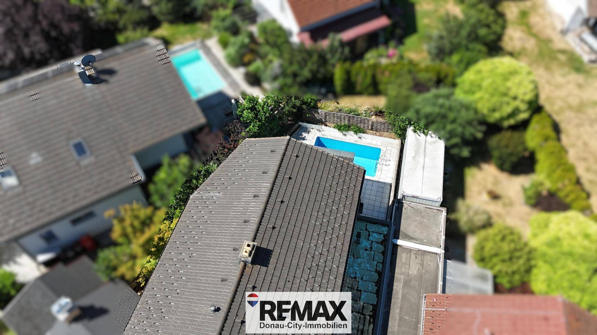 Vogelperspektive des Hauses mit Dach und dem angrenzenden Swimmingpool.