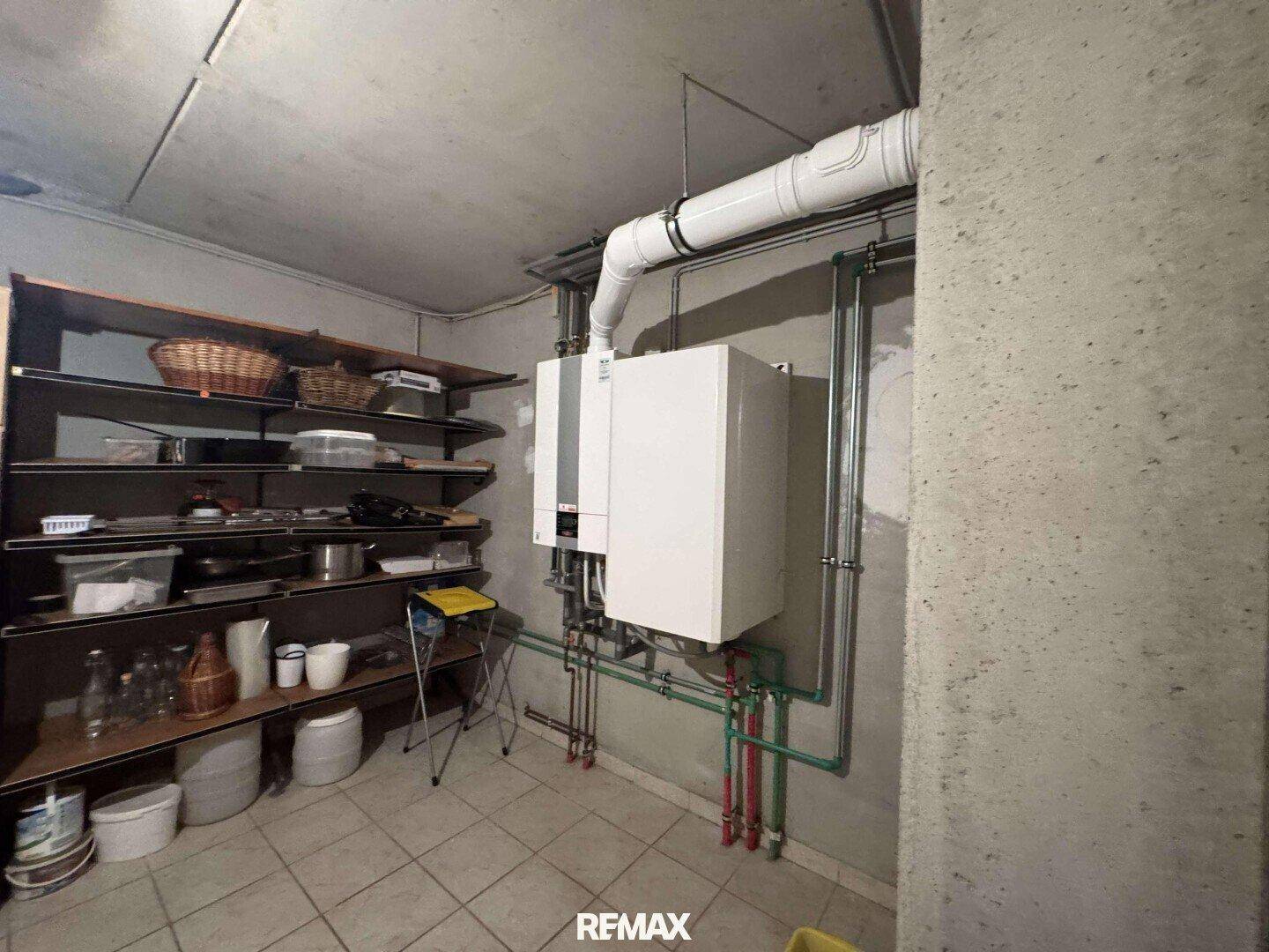 Heizungsraum im Keller mit Regalen und technischen Installationen.