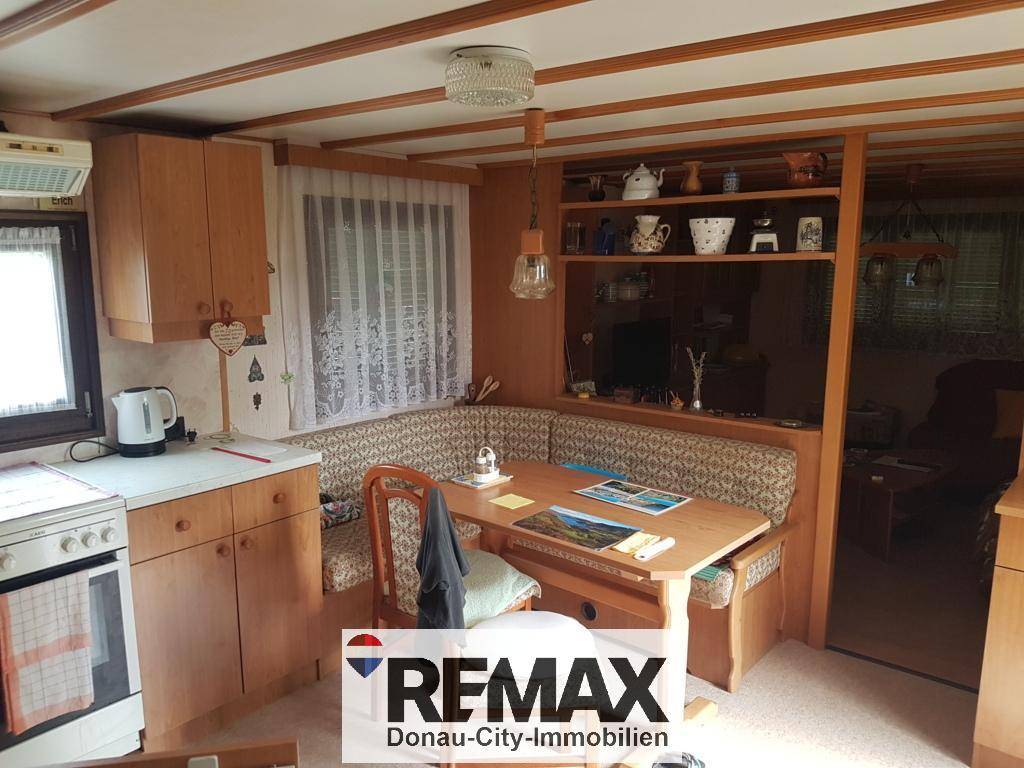 Gemütliche Essecke in der Küche mit Holztisch und Sitzbank, umgeben von Holzmöbeln.