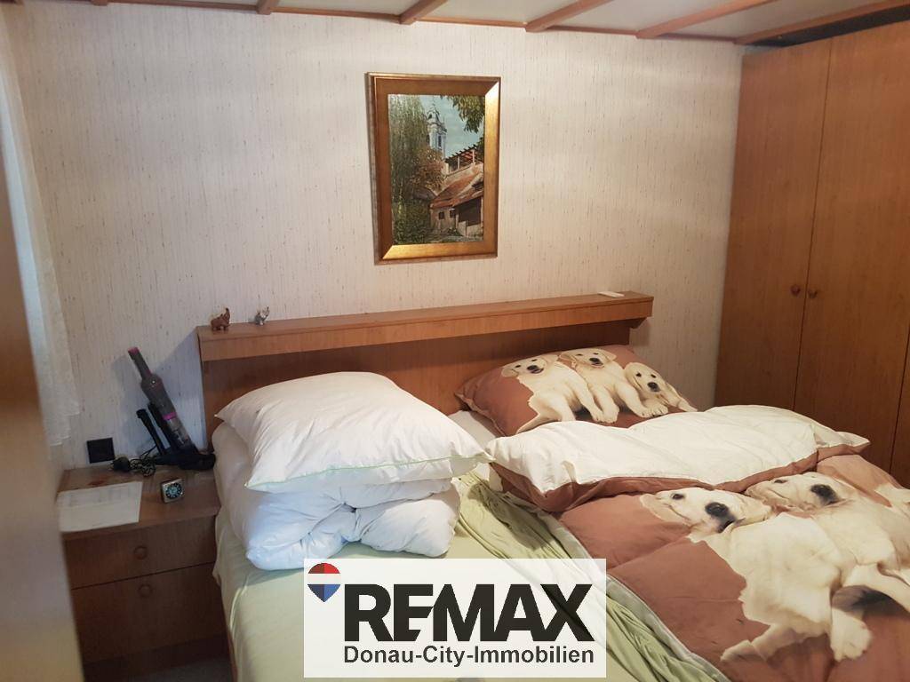 Schlafzimmer mit Doppelbett, Holzmöbeln und einem Bild an der Wand.