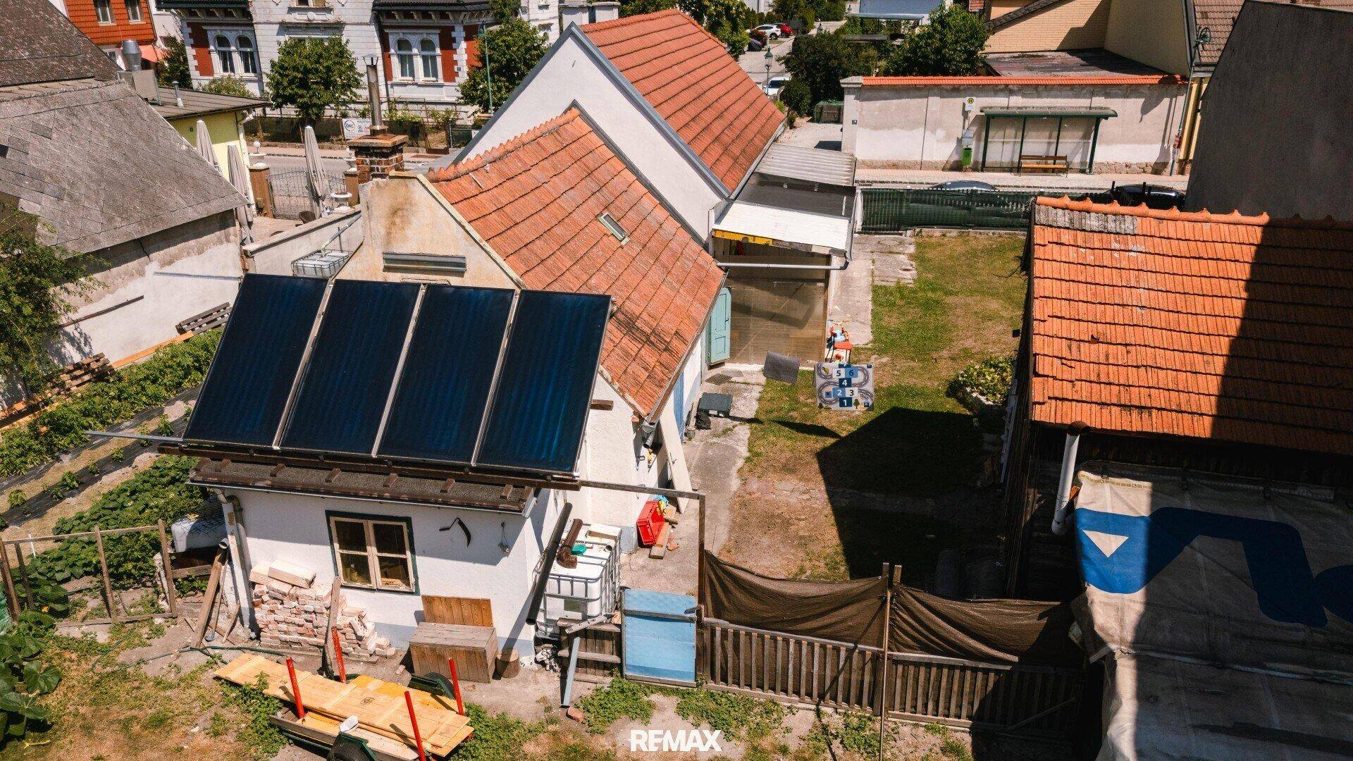Luftaufnahme des Hauses mit Solaranlage auf dem Dach und angrenzenden Gärten.