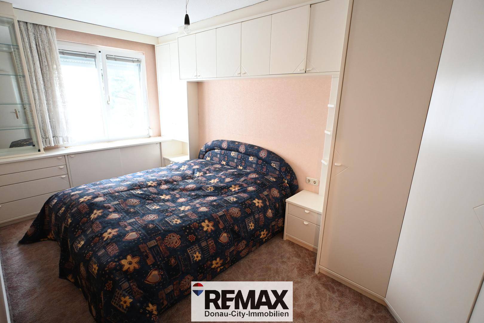 Schlafzimmer mit Doppelbett, Teppichboden und Einbauschränken, bietet Stauraum.