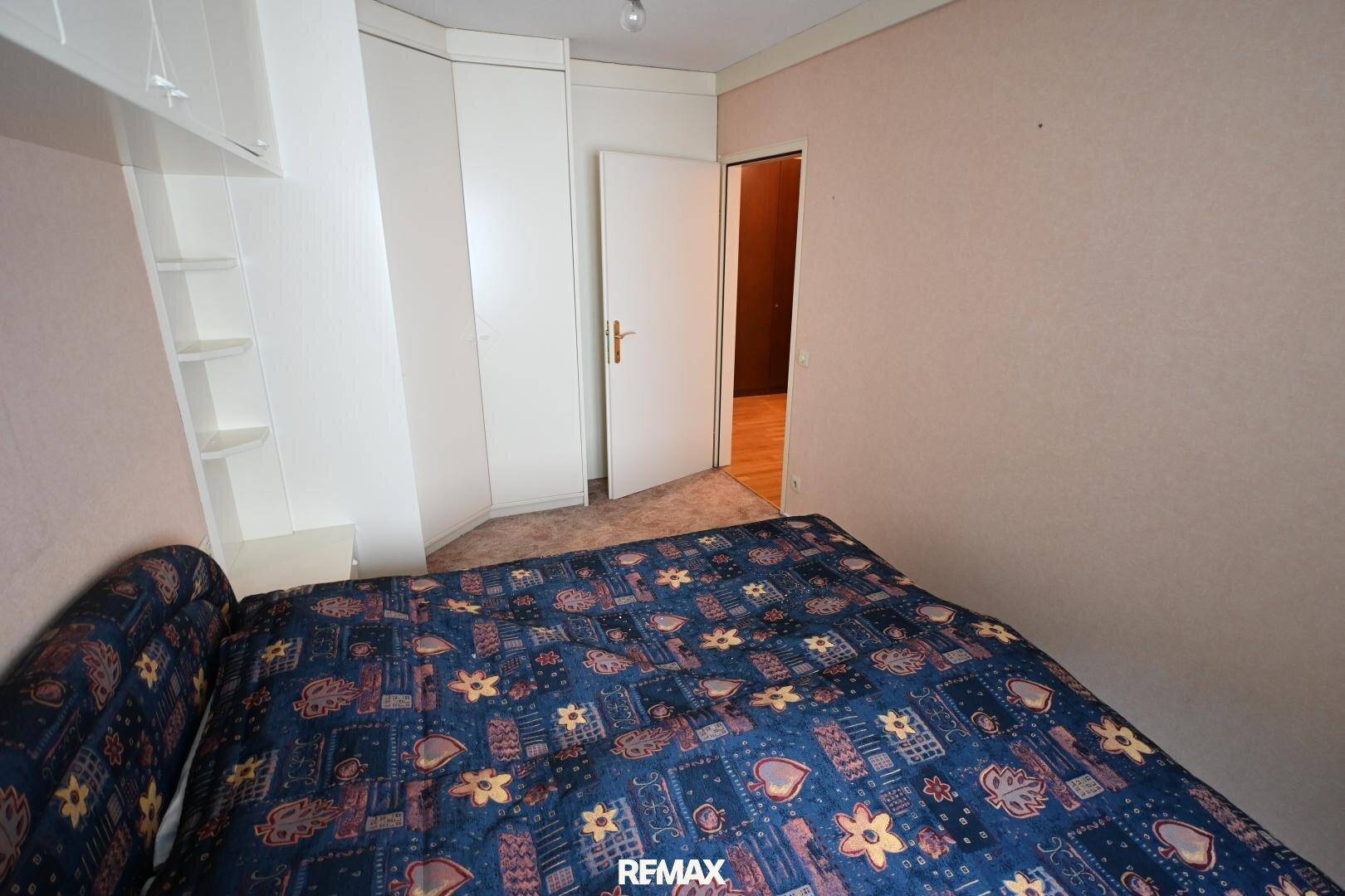 Schlafzimmer mit Teppichboden und Einbauschränken, bietet viel Stauraum und Komfort.