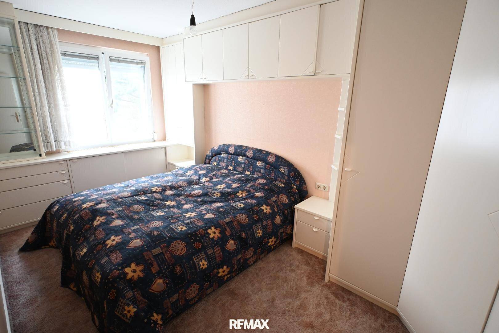 Schlafzimmer mit Doppelbett, Einbauschränken und Teppichboden, gemütlich und praktisch.