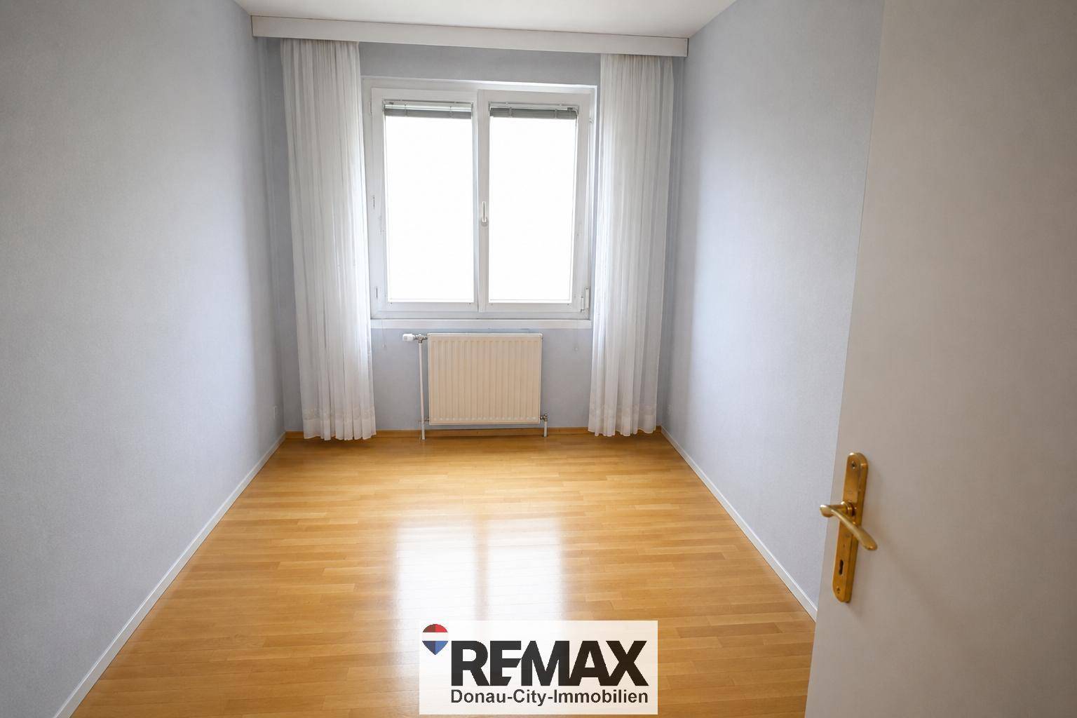 Kleines Zimmer mit hellem Parkettboden und Fenster, ideal als Schlaf- oder Arbeitszimmer.