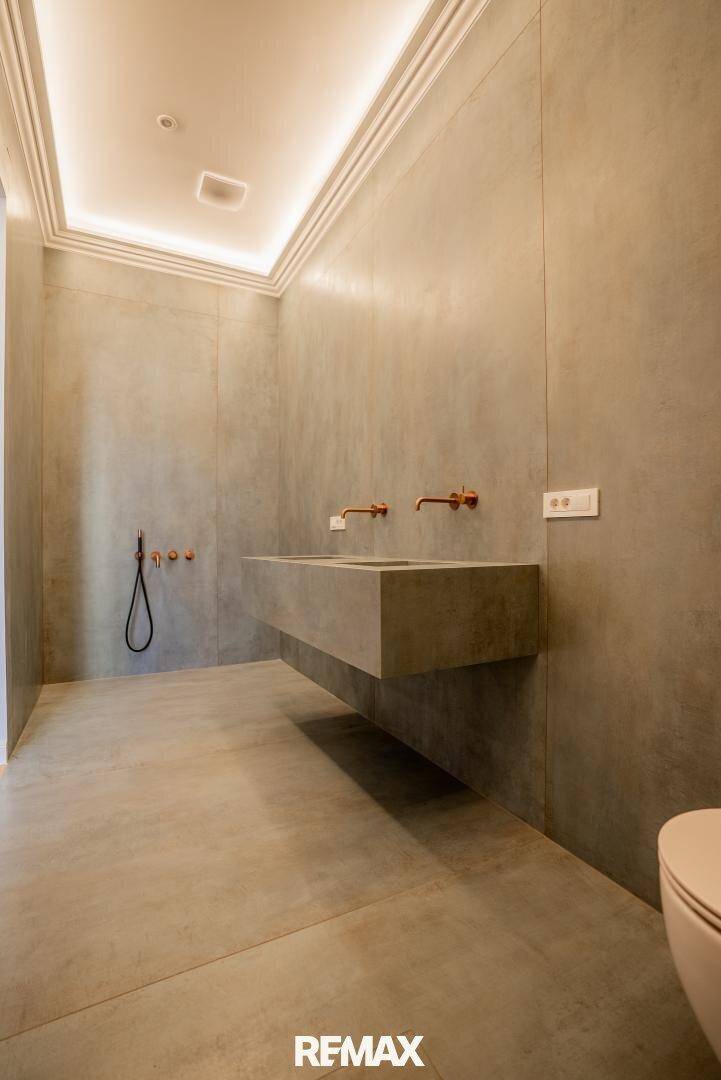 Modernes Badezimmer mit Doppelwaschbecken aus Stein und minimalistischem Design.