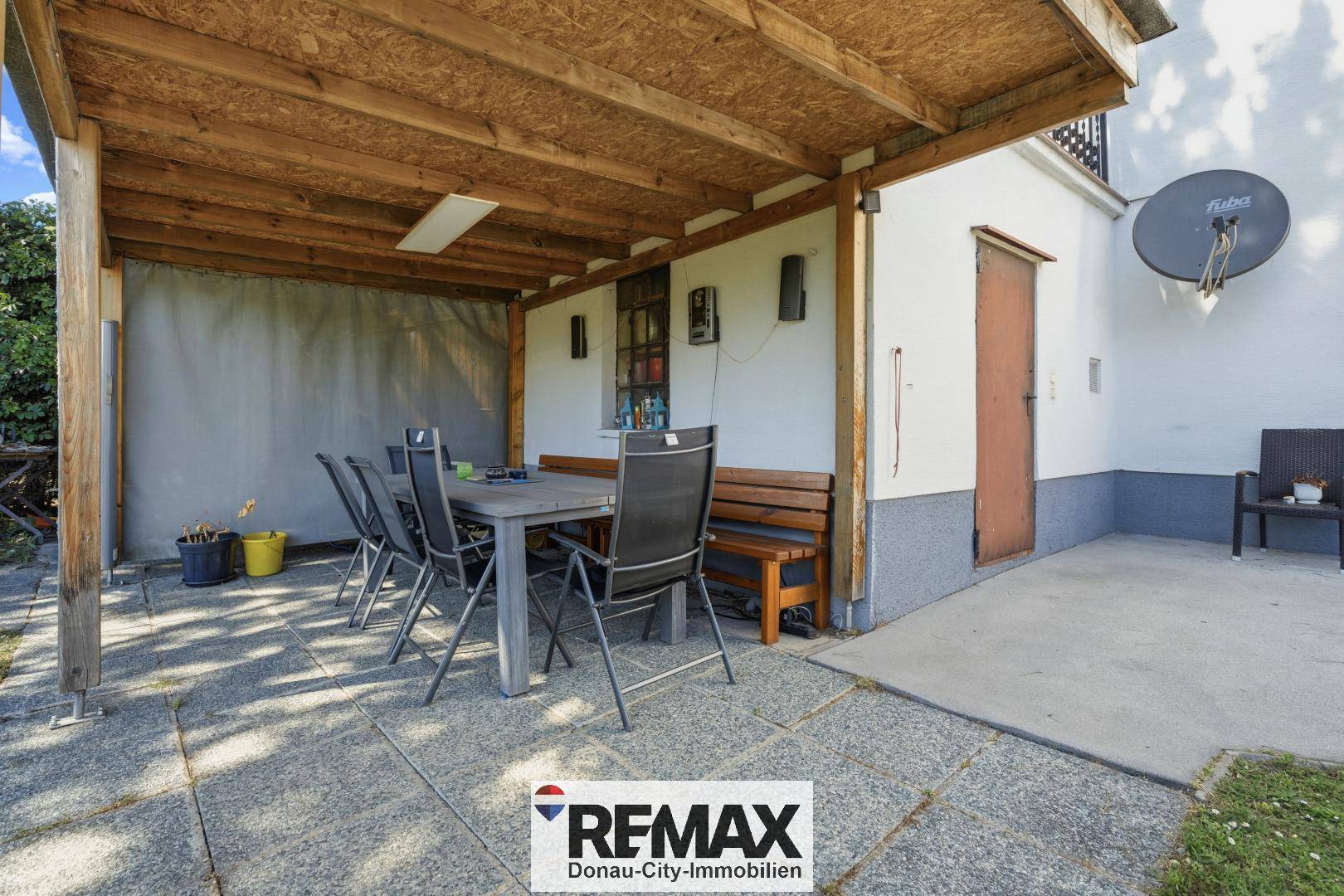 Überdachte Terrasse mit Holzdach und Esstisch für gemütliche Stunden im Freien.