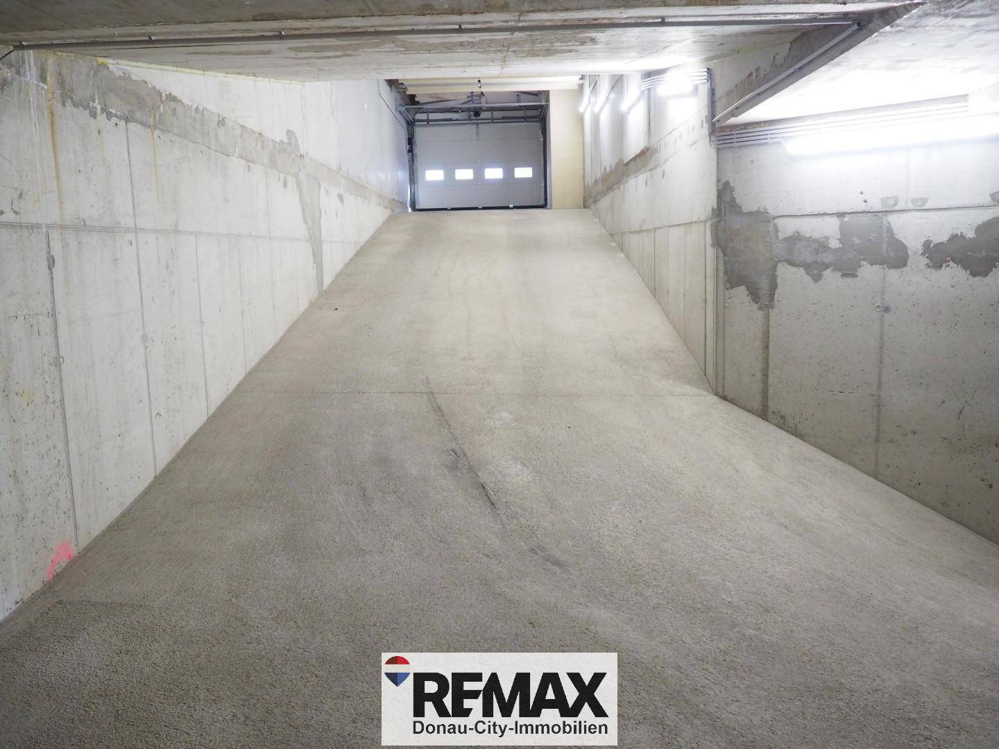 Die Zufahrtsrampe zur Tiefgarage ist breit und gut beleuchtet für bequemes Parken.