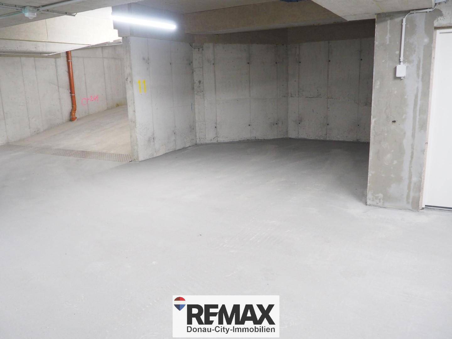 Geräumige Tiefgarage mit Betonwänden und -boden, bereit für die Nutzung im Neubau.