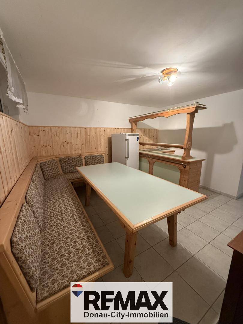 Gemütlicher Raum im Untergeschoss mit Holzvertäfelung, Sitzbank und einer Bar.